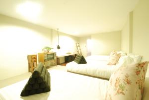 um quarto de hotel com duas camas e uma televisão em Pak Ping The Cozy Living in Chiangmai em Chiang Mai