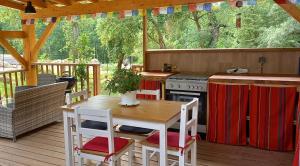 a kitchen with a table and a stove on a deck at Yourte indépendante en pleine nature, proche d'Ajaccio in Carbuccia