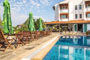 a hotel with a swimming pool with chairs and umbrellas at Family Hotel Saint Konstantin in Glavatartsi