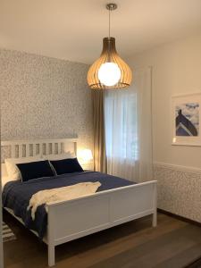 a bedroom with a bed and a chandelier at Vila MAY in Juodkrantė