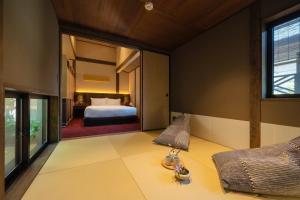 a bedroom with a bed and a large window at THE MACHIYA KAZAHAYA in Kyoto +32 photos