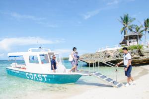 eine Gruppe von Männern, die auf einem Boot am Strand stehen in der Unterkunft Coast Boracay in Boracay