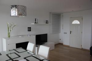 a white living room with a table and a television at Sierra de Chiva Villa in Chiva