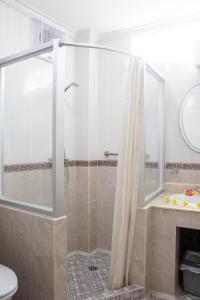 ein Bad mit einer Dusche, einem Waschbecken und einem WC in der Unterkunft Bali Seascape Beach Club in Candidasa