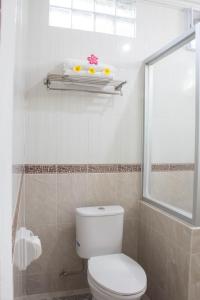 een badkamer met een wit toilet en een raam bij Bali Seascape Beach Club in Candidasa