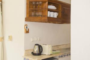 a kitchen with wooden cabinets and a toaster on a counter at Bali Seascape Beach Club in Candidasa