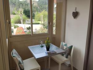 mesa y sillas en una habitación con ventana en Studio belles prestations en Cévennes en Chamborigaud