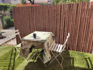 una mesa y sillas en un patio junto a una valla en Studio belles prestations en Cévennes en Chamborigaud