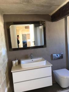 a bathroom with a sink and a toilet and a mirror at House of Character in Historical Rabat in Rabat