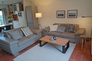 uma sala de estar com dois sofás e uma mesa de centro em Strandgeluk, Joost de Moorstraat 6 em Cadzand
