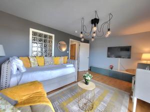 uma sala de estar com um sofá e uma televisão em 4 Separate Beds, Sleeps 6, Beautiful 2 bed Apt em Edimburgo