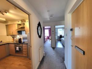 uma cozinha com um corredor que leva a uma sala de estar em 4 Separate Beds, Sleeps 6, Beautiful 2 bed Apt em Edimburgo
