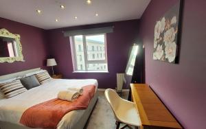 um quarto com uma cama, uma secretária e uma janela em 4 Separate Beds, Sleeps 6, Beautiful 2 bed Apt em Edimburgo