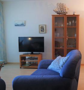 salon z niebieską kanapą i telewizorem w obiekcie Seaview, Deurloo 53-12 Cadzand w mieście Cadzand