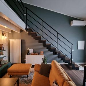 un soggiorno con divano e scale di 3 MURA rooms a Teulada