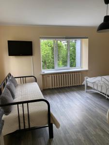 a room with two beds and a tv and two windows at 9 Mežmalas iela in Jūrmala