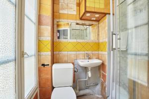 La petite salle de bains est pourvue de toilettes et d'un lavabo. dans l'établissement Le Petit Borda, à Paris