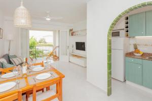 a kitchen and living room with a table and a dining room at Los Delfines Biniforcat in Ciutadella