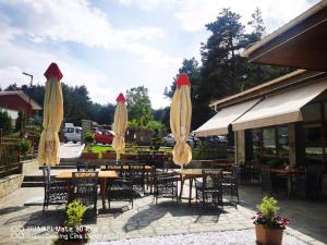 a group of tables and chairs with umbrellas at Family Hotel The View & SPA in Tsigov Chark