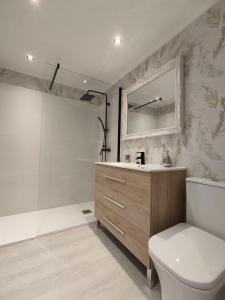 a bathroom with a toilet and a sink and a mirror at Acogedor apartamento junto a la Plaza in Villasana de Mena