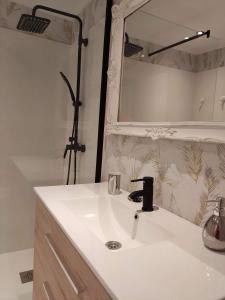 a bathroom with a white sink and a mirror at Acogedor apartamento junto a la Plaza in Villasana de Mena +9 photos