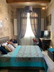 een slaapkamer met een bed, een televisie en een raam bij House of Character in Historical Rabat in Rabat