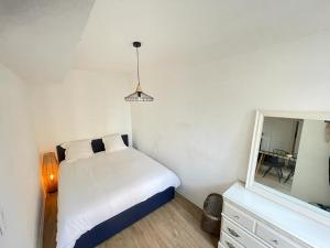 um pequeno quarto com uma cama e um espelho em Le petit Cordelier em Dinan