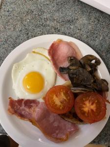a breakfast plate with an egg bacon tomatoes and mushrooms at Dunarle Guesthouse in Oban