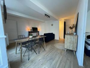 uma sala de estar com uma mesa e cadeiras e um sofá em Le petit Cordelier em Dinan