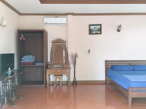 ein Schlafzimmer mit einem Bett, einem Tisch und einem Stuhl in der Unterkunft Phatra Hostel in Thongsala