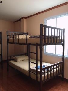 2 Etagenbetten in einem Zimmer mit Fenster in der Unterkunft Phatra Hostel in Thongsala