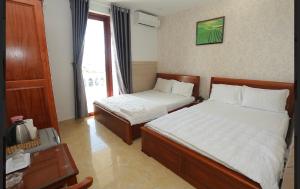 Postel nebo postele na pokoji v ubytování Kim Ngoc Khanh Hotel