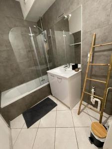 uma casa de banho com um chuveiro, um lavatório e uma banheira em Le petit Cordelier em Dinan