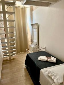 ein Schlafzimmer mit einem Bett und einer Wendeltreppe in der Unterkunft Nido di pietra-dimora in centro in Alberobello
