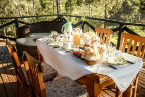 a table with a blue table cloth and baskets of food at Yurt Tree, romântico e confortável, experiência unica in Jacutinga