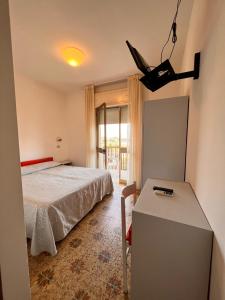 een slaapkamer met een bed, een tafel en een raam bij Hotel Calypso in Bellaria-Igea Marina