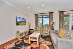 a living room with a couch and a table at Villa 2br Frambois Villa located within Cypress Lakes Resort in Pokolbin