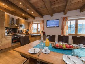 a kitchen with a wooden table with chairs and a television at Apartment in Kaprun with Ski-in Ski-out Access in Kaprun