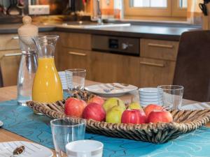 a table with a basket of apples and a bottle of juice at Apartment in Kaprun with Ski-in Ski-out Access in Kaprun