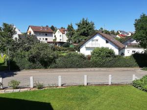 a white fence in front of a house at Apartment Bodenseesonne in Immenstaad am Bodensee