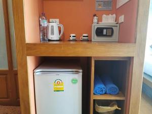 uma pequena cozinha com frigorífico e micro-ondas em BaanMee Phuket SHA Plus em Chalong