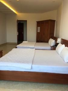 Postel nebo postele na pokoji v ubytování Kim Ngoc Khanh Hotel