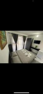 a bedroom with a large bed and a window at Pensiunea BELVEDERE YACHTCLUB Berzasca in Berzasca