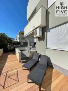 a patio with two chairs and a table on a building at Apartment High Five Novalja in Novalja