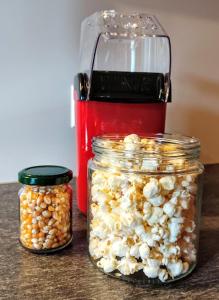 zwei Gläser Popcorn und ein rotes Gerät auf dem Tisch in der Unterkunft HAPPY PLACE Pusteblume in Halblech