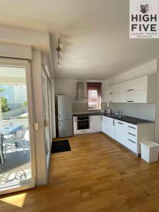 a large kitchen with white cabinets and a table with a table at Apartment High Five Novalja in Novalja
