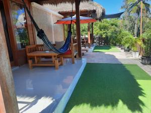 a patio with a hammock and chairs and grass at Molah Gili Villa in Gili Air