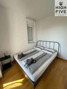 a bed in a white room with a bed frame at Apartment High Five Novalja in Novalja