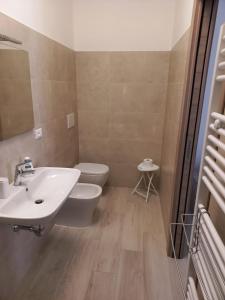 ein Badezimmer mit einem weißen Waschbecken und einem WC in der Unterkunft Alloggio del generale in Viterbo