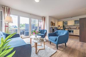 een woonkamer met twee blauwe stoelen en een tafel bij fewo1846 - Schotstek - komfortable 2-Zimmer-Wohnung mit Terrasse in Harrislee
